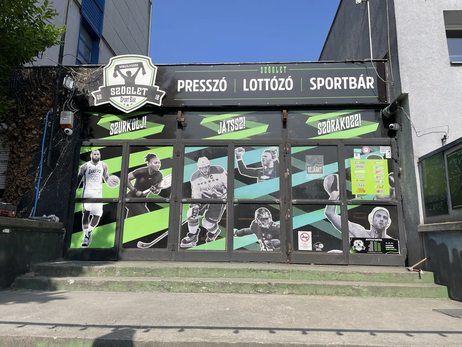 A Szöglet Sport Bár bejárata, Dunaújváros, Béke tér 3.